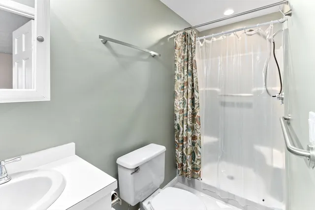 a bathroom with a shower a toilet and a sink