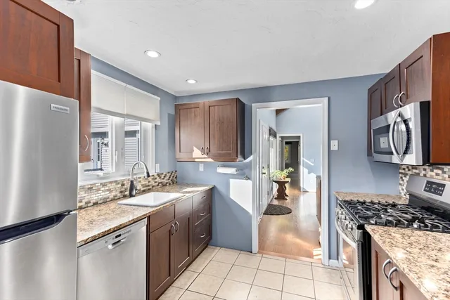 a kitchen with stainless steel appliances granite countertop a sink stove and refrigerator