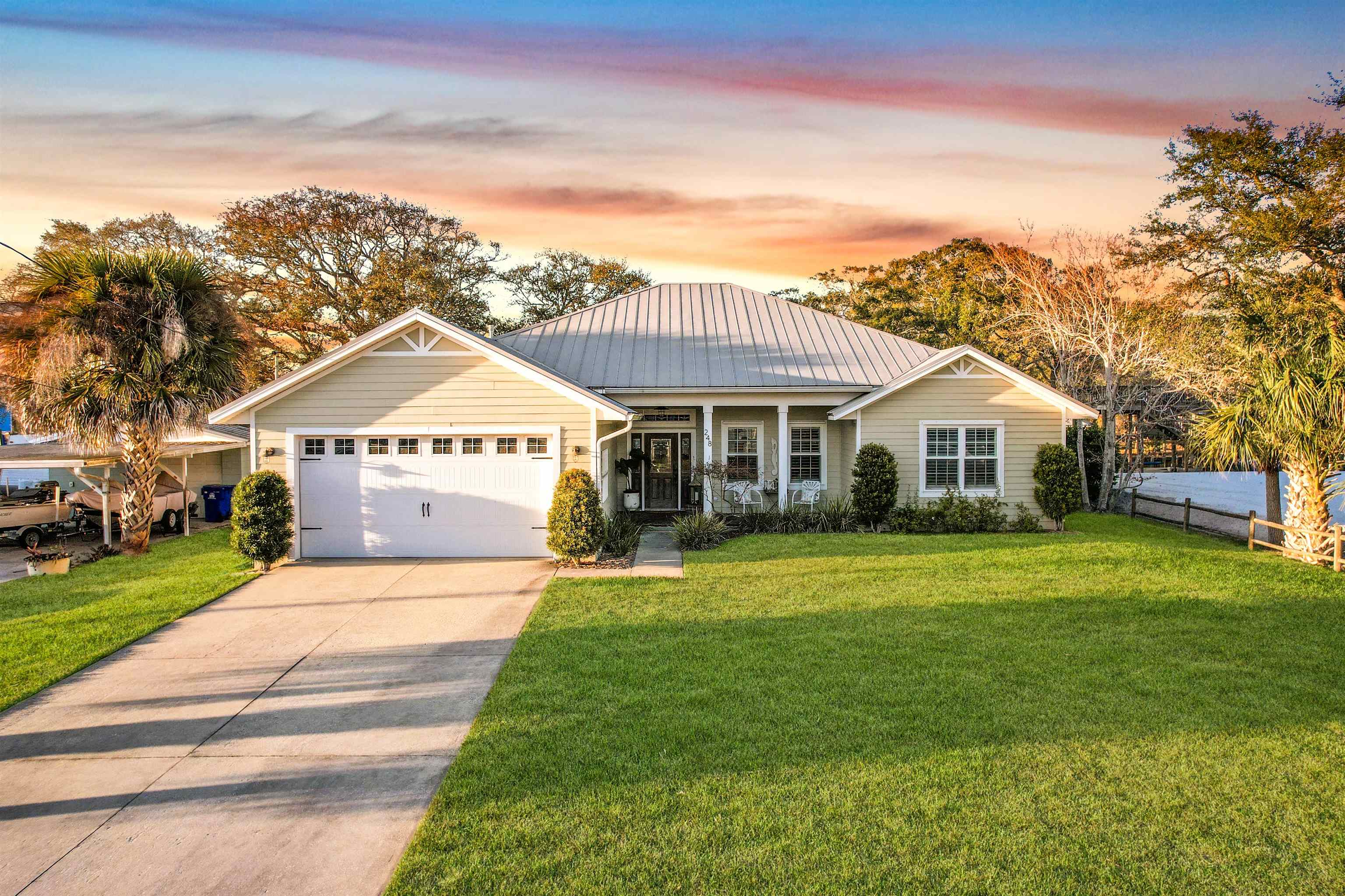 248 Pizarro Road St. Augustine, FL 32080 - Photo 3 of 53 View of front of house featuring a porch, concrete driveway, an attached garage, and a standing seam roof