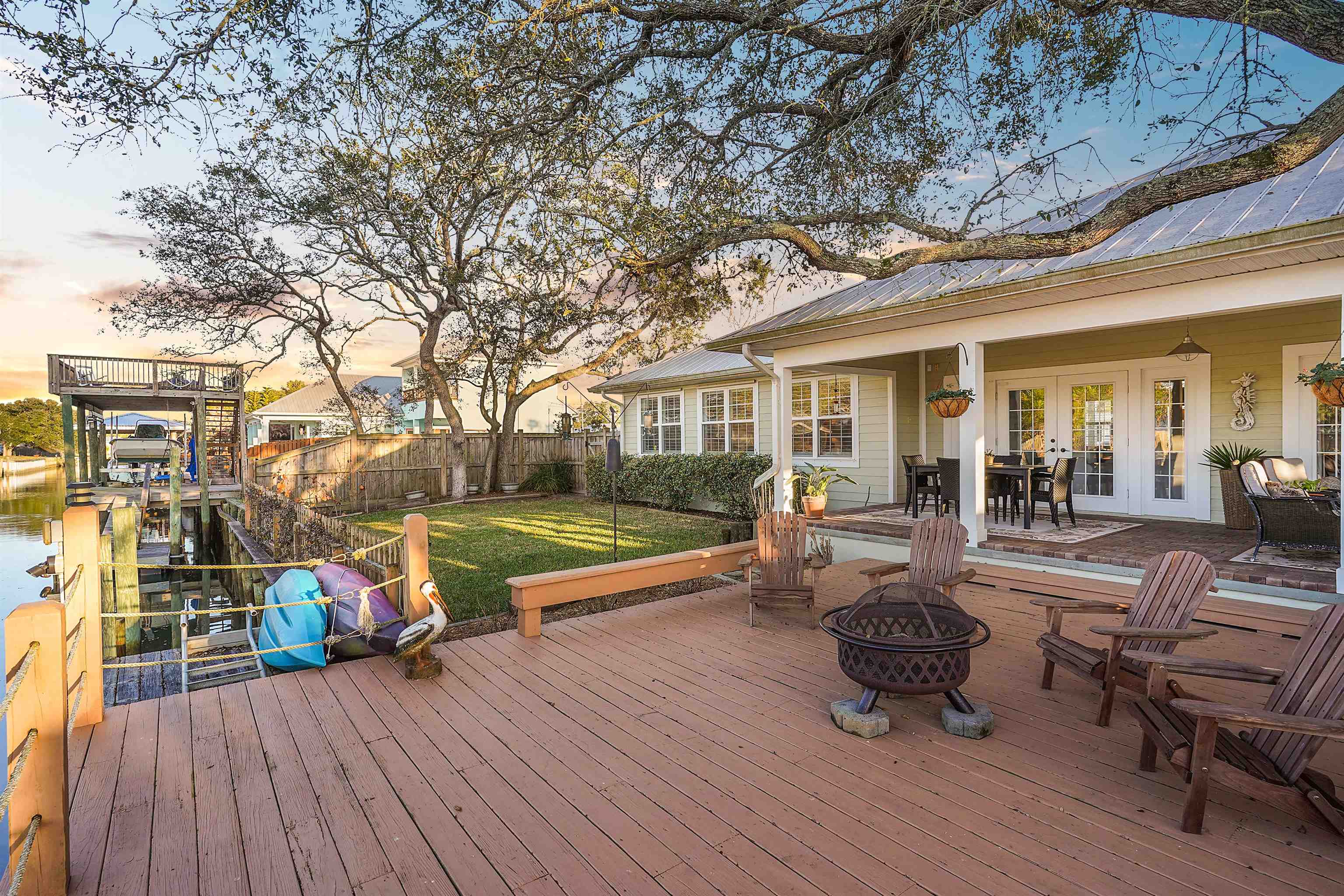 248 Pizarro Road St. Augustine, FL 32080 - Photo 42 of 53 Deck at dusk featuring a patio, french doors, outdoor dining area, an outdoor fire pit, and a boat dock