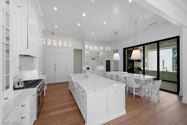 6285 Highcroft Drive Naples, FL 34119 - Photo 18 of 50 a large white kitchen with large window and stainless steel appliances