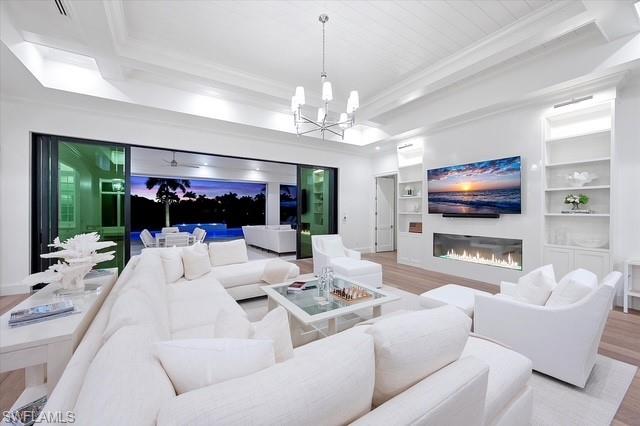6285 Highcroft Drive Naples, FL 34119 - Photo 2 of 50 a living room with furniture a flat screen tv and a large window