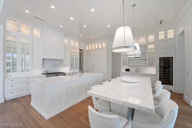 6285 Highcroft Drive Naples, FL 34119 - Photo 22 of 50 a kitchen with stainless steel appliances kitchen island granite countertop a stove a sink a dining table and chairs