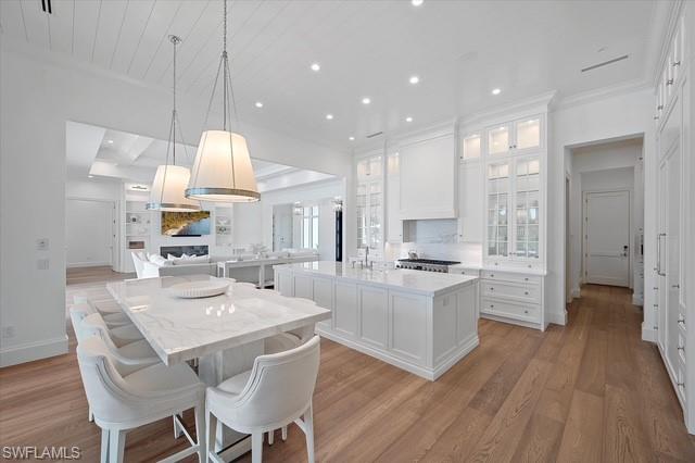 6285 Highcroft Drive Naples, FL 34119 - Photo 24 of 50 a kitchen with a table chairs refrigerator and cabinets