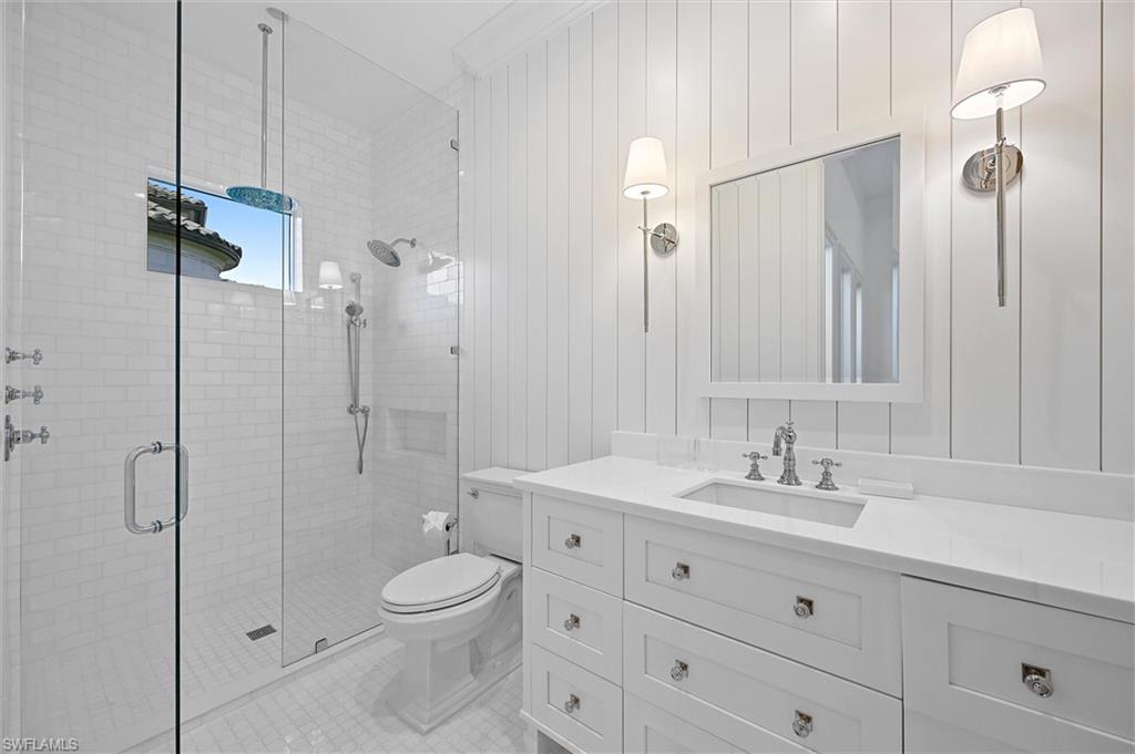 6285 Highcroft Drive Naples, FL 34119 - Photo 35 of 50 a bathroom with a toilet a sink a mirror a shower and vanity