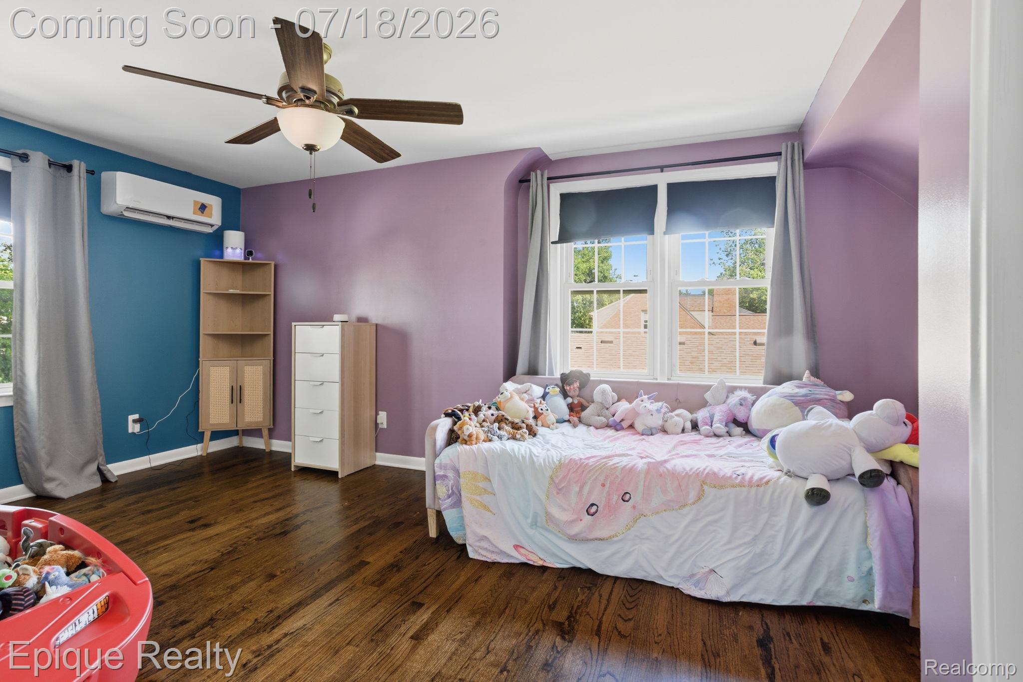 1206 Hawthorne Road Grosse Pointe, MI 48236 - Photo 18 of 28 Interior room featuring wood-finish flooring, two large windows with natural light, a ceiling fan with light fixture, and a wall-mounted mini-split system