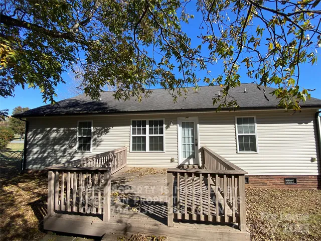 a view of a house with a window and wooden fence