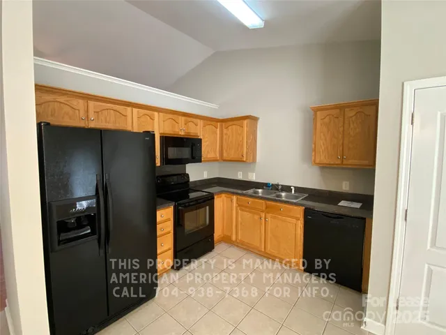a kitchen with stainless steel appliances granite countertop a refrigerator and a stove top oven