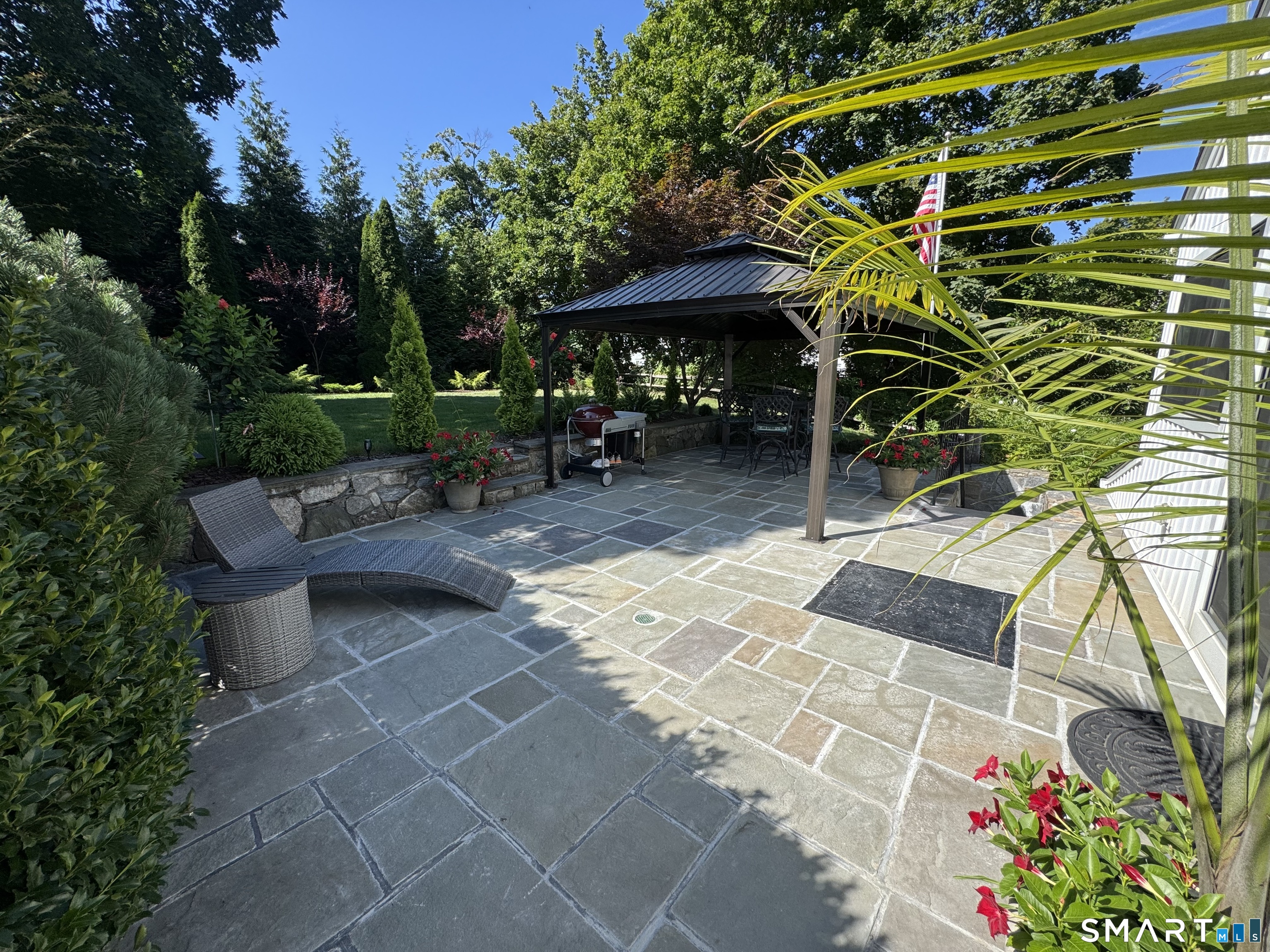 561 River Road Greenwich, CT 06870 - Photo 4 of 6 a view of a patio with table and chairs potted plants and large tree