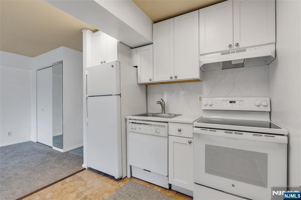 233 12th Street, Unit 3H Palisades Park, NJ 07650 - Photo 8 of 10 a kitchen with white cabinets and white appliances