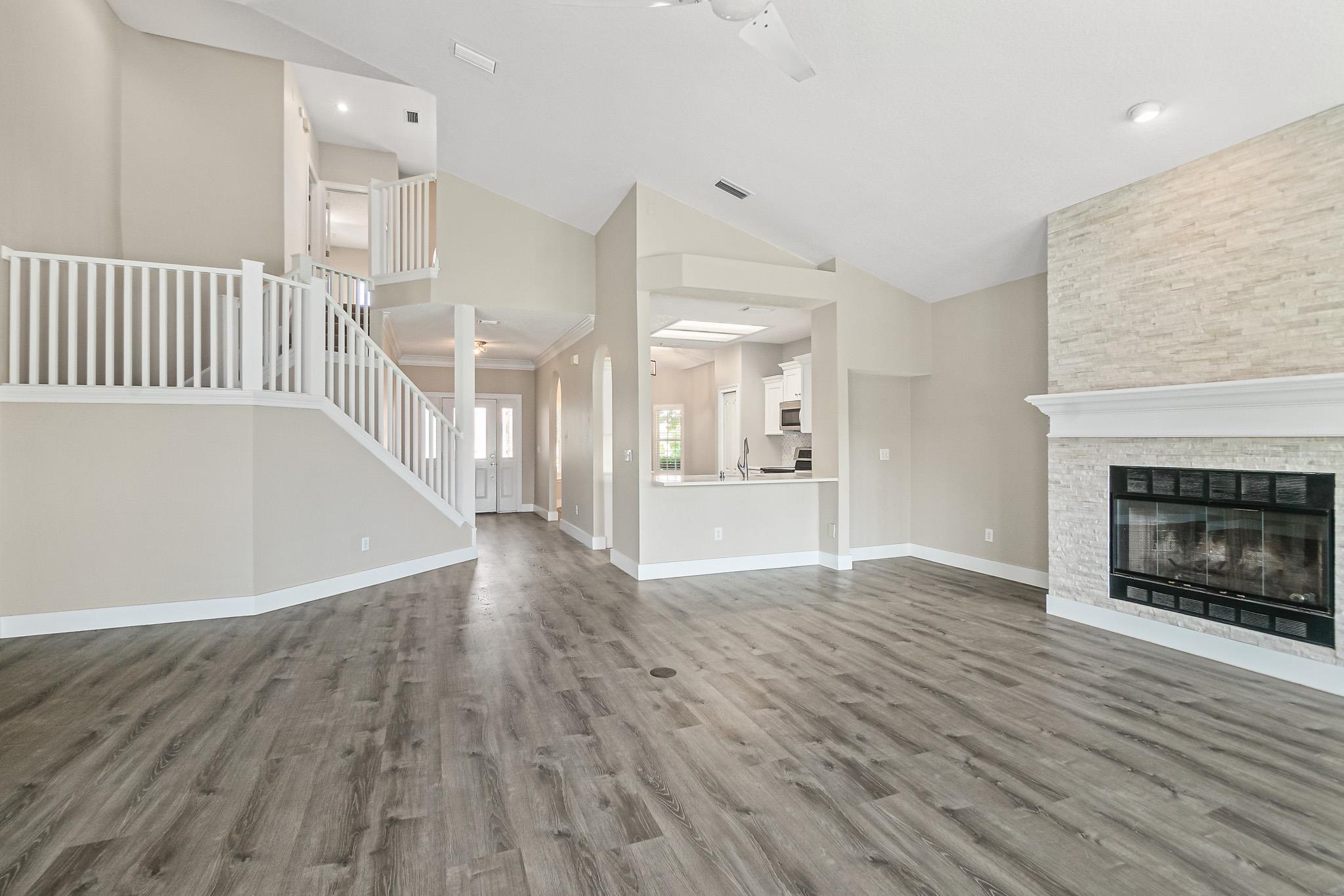 Undisclosed Address St. Augustine, FL 32080 - Photo 11 of 58 a view of an empty room with wooden floor fire place and a kitchen