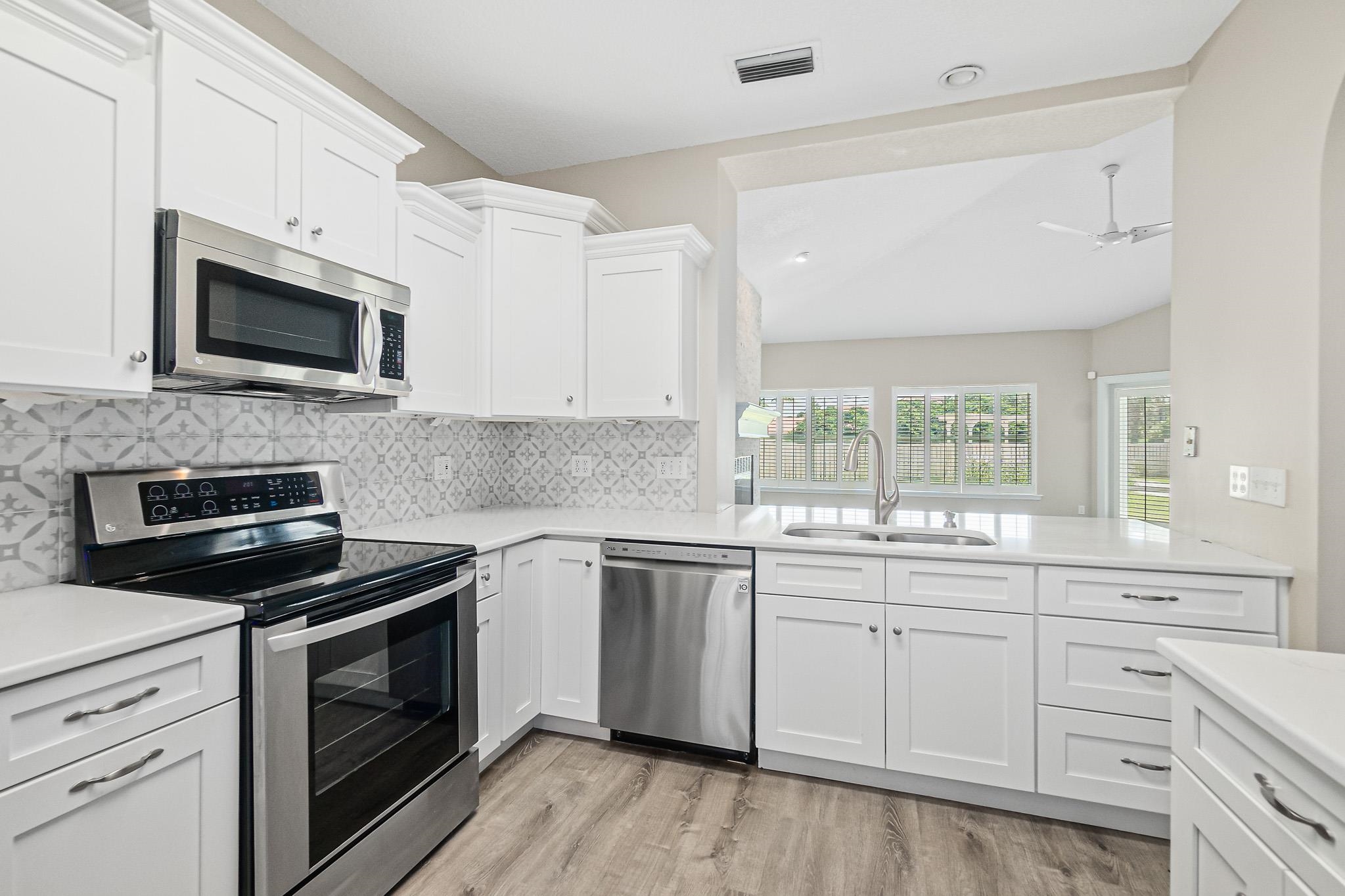 Undisclosed Address St. Augustine, FL 32080 - Photo 19 of 58 a kitchen with white cabinets and appliances