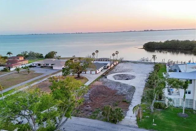 an aerial view of a city with lots of residential buildings and ocean view in back