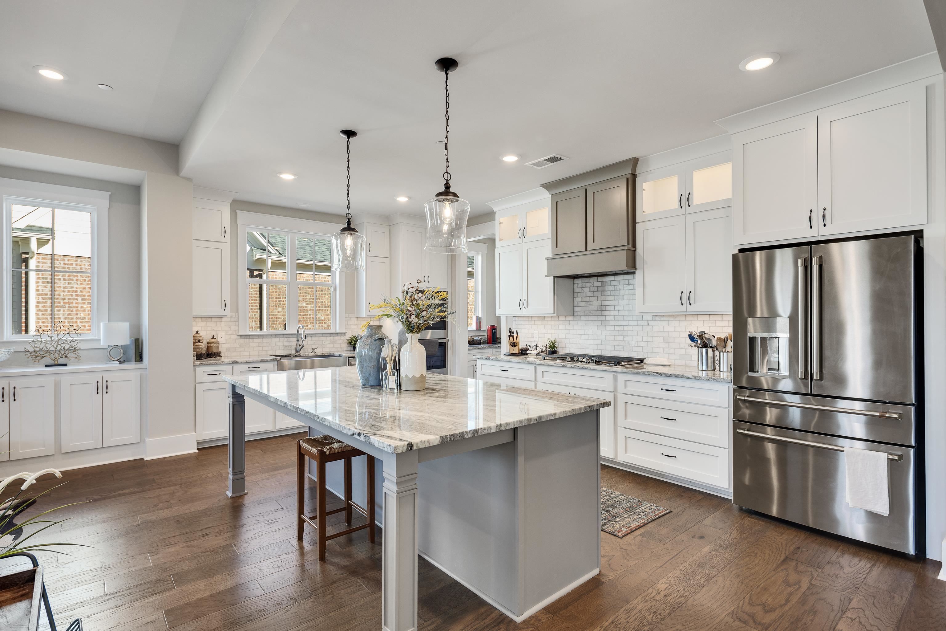 60 Old Pasture Lane Collierville, TN 38017 - Photo 15 of 36 a kitchen with stainless steel appliances granite countertop a sink a stove a refrigerator and island with wooden floor