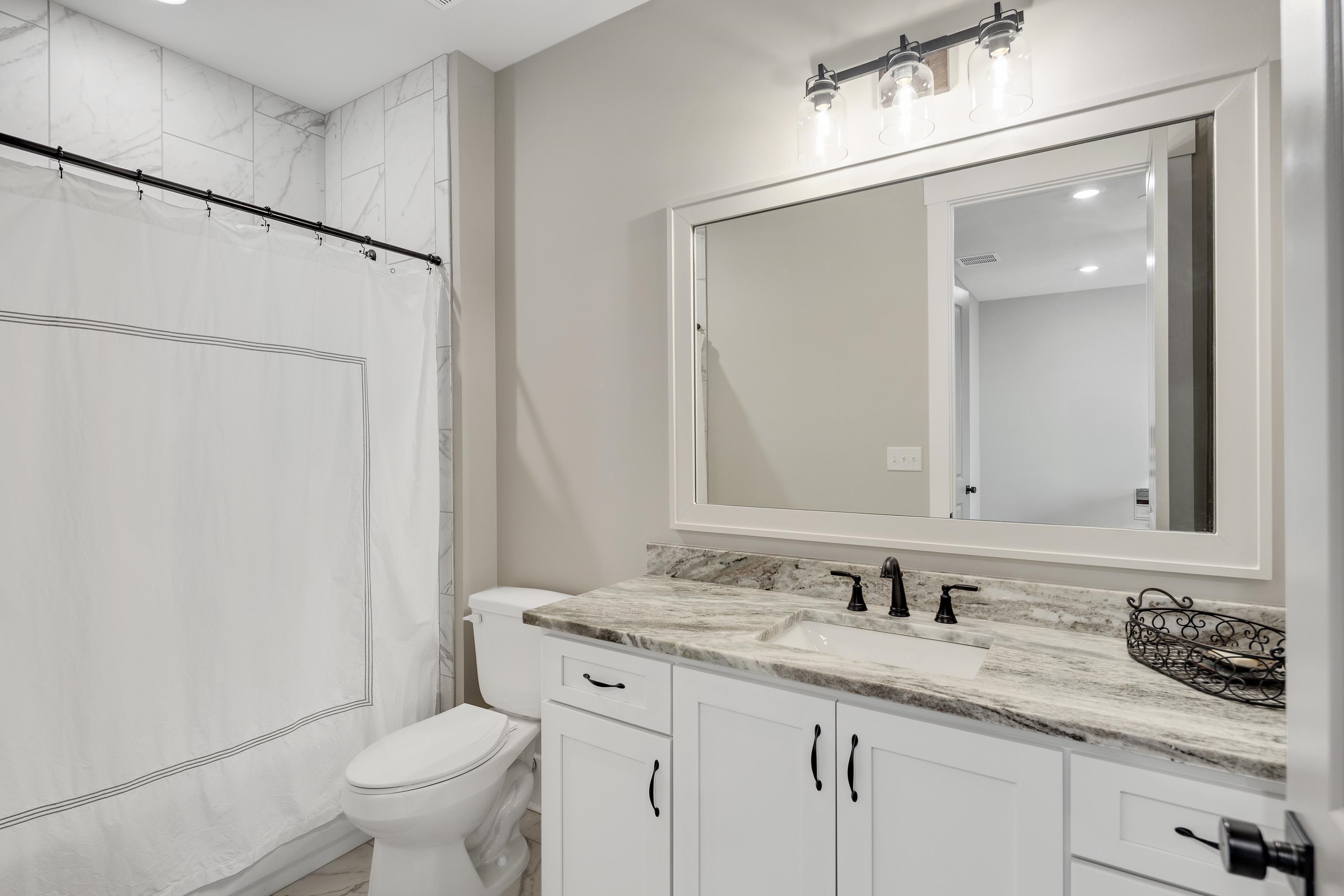 60 Old Pasture Lane Collierville, TN 38017 - Photo 19 of 36 a bathroom with a granite countertop sink a toilet and a mirror
