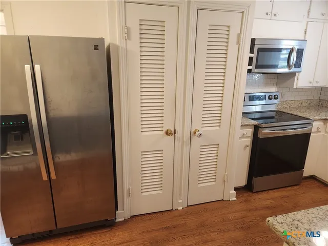 a metallic refrigerator freezer sitting in a kitchen