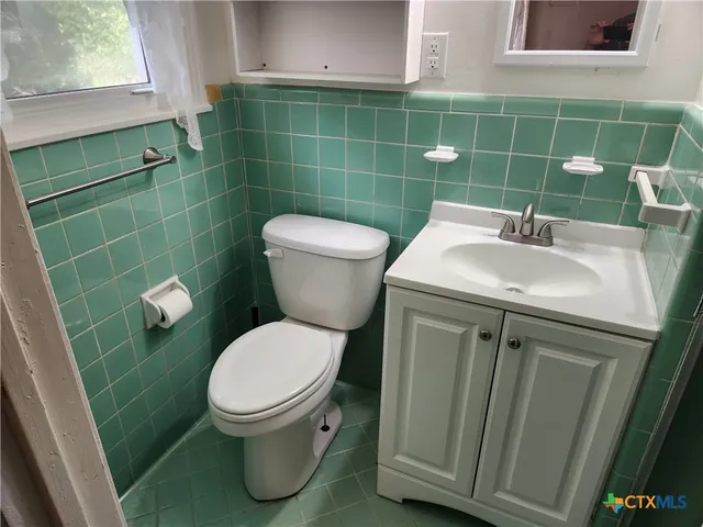 a bathroom with a sink a toilet and a mirror