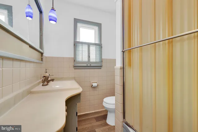 a bathroom with a sink mirror and a toilet