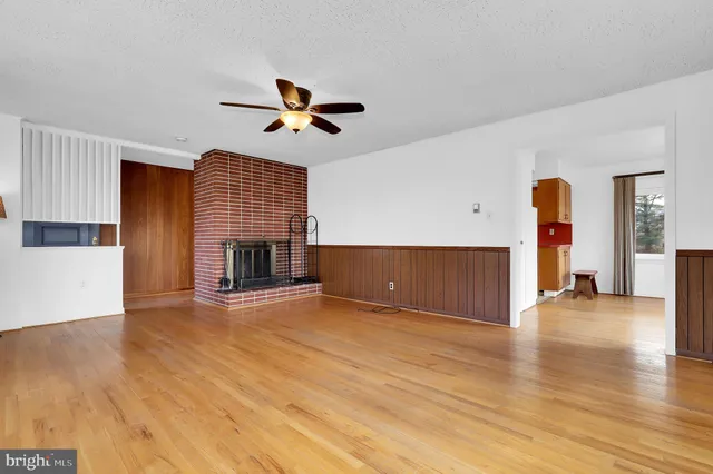 a view of empty room with wooden floor and fireplace