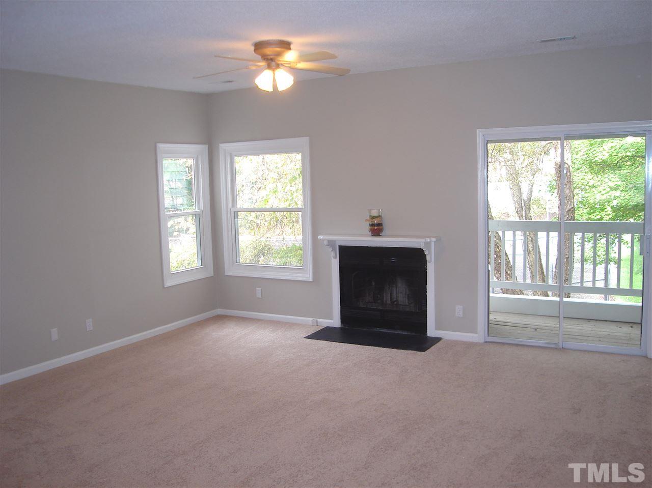 6151 Summer Pointe Place, Unit 202 Raleigh, NC 27606 - Photo 3 of 21 an empty room with windows and fireplace