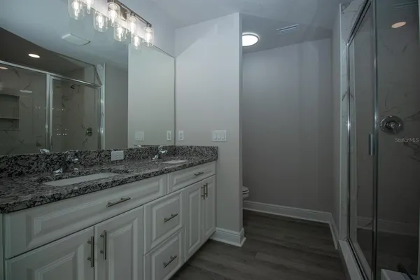 a bathroom with a granite countertop sink a large mirror and a vanity