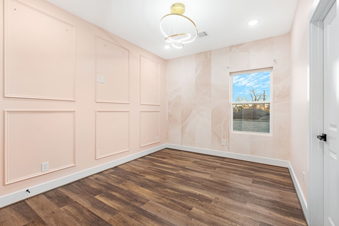 907 Pollard Street, Unit B Houston, TX 77020 - Photo 22 of 30 a view of an empty room with wooden floor and a window