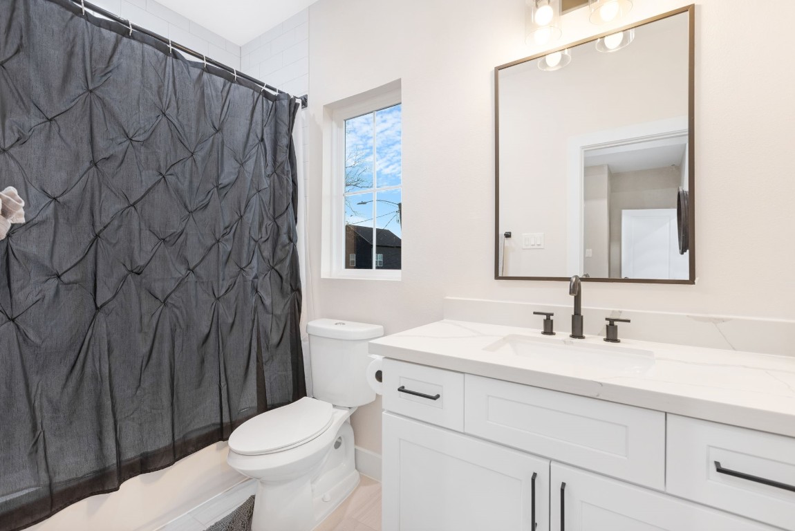 907 Pollard Street, Unit B Houston, TX 77020 - Photo 25 of 30 a bathroom with a toilet a sink and a mirror