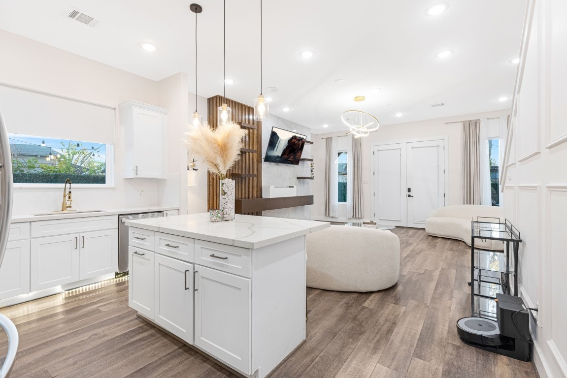 907 Pollard Street, Unit B Houston, TX 77020 - Photo 7 of 30 a large white kitchen with a sink a stove and wooden floor