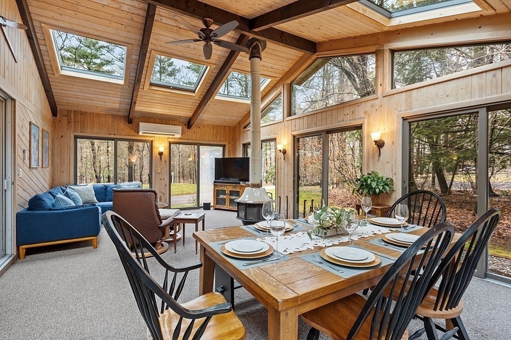 66 Old Right Road Ipswich, MA 01938 - Photo 12 of 36 a view of a dining room with furniture large windows wooden floor and garden view