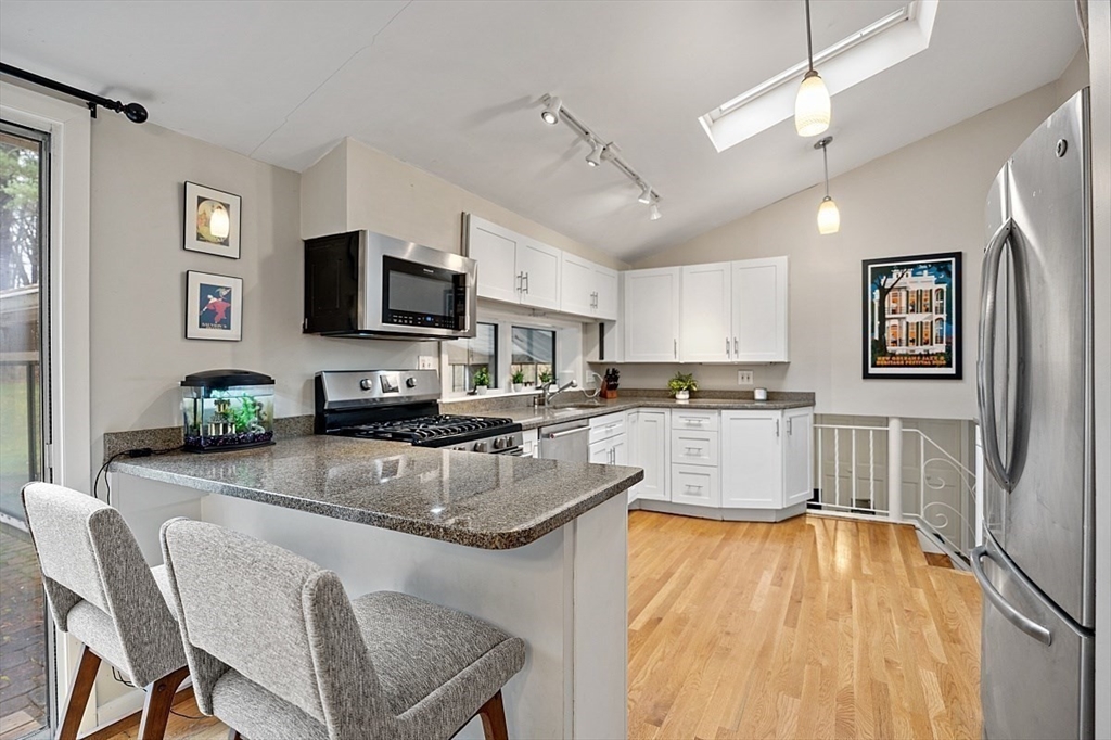 66 Old Right Road Ipswich, MA 01938 - Photo 9 of 36 a kitchen with stainless steel appliances granite countertop a stove top oven a sink dishwasher a dining table and chairs with wooden floor