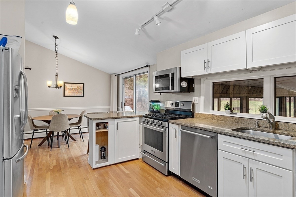 66 Old Right Road Ipswich, MA 01938 - Photo 10 of 36 a kitchen with white cabinets stainless steel appliances and wooden floor