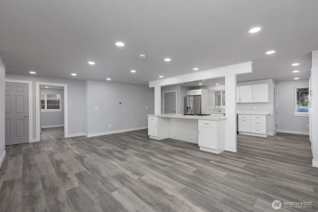 a view of kitchen with kitchen island refrigerator and wooden floor