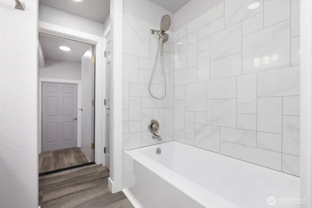 a bathroom with a tub shower and vanity