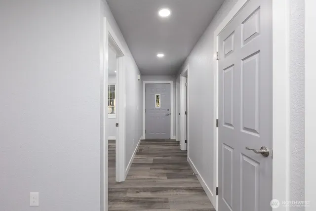 a view of a hallway with wooden floor