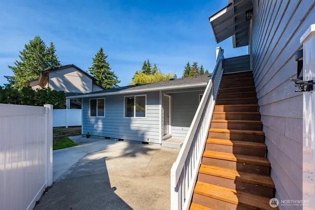 a view of a house with backyard and sitting area