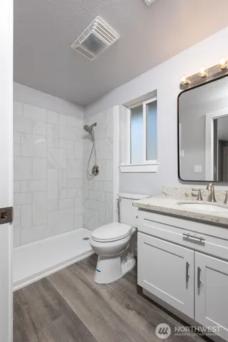 a bathroom with a double vanity sink toilet mirror and shower