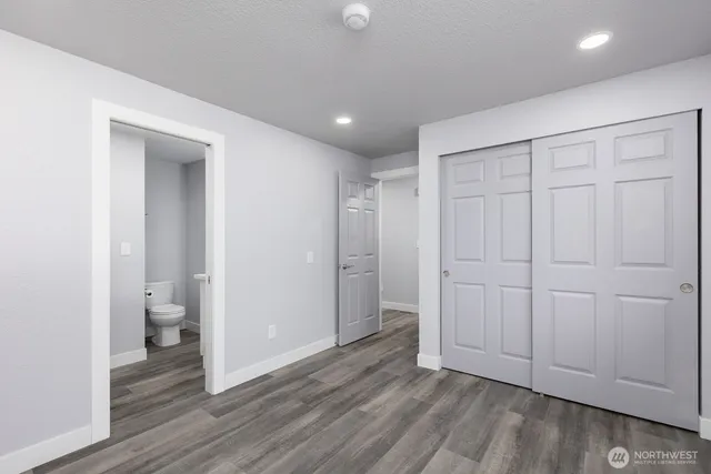 wooden floor in an empty room with a bathroom