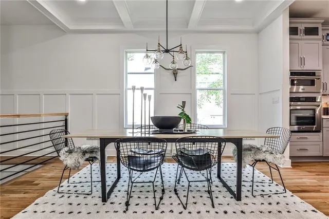 a dining room filled chandelier and wooden floor