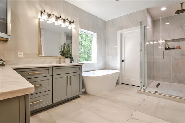 a spacious bathroom with a granite countertop sink a toilet a mirror and shower