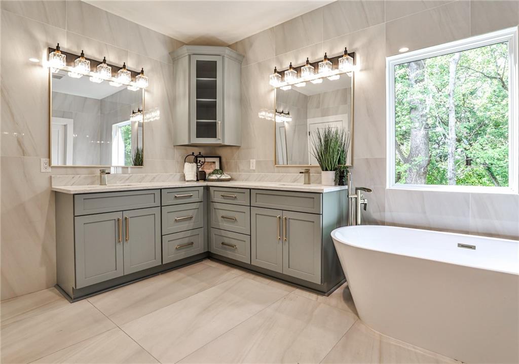 1401 Rupert Road Decatur, GA 30030 - Photo 19 of 43 a spacious bathroom with a double vanity sink a large mirror a bathtub and next to a window