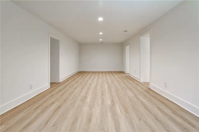a view of empty room with wooden floor