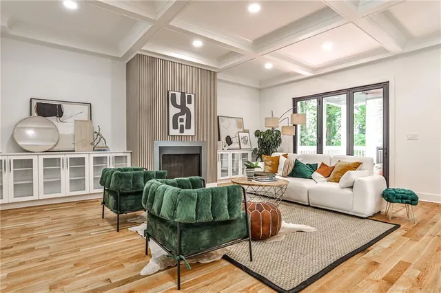 a living room with furniture a fireplace and a large window