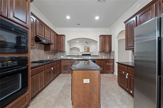 a kitchen with stainless steel appliances granite countertop a stove top oven a sink and dishwasher