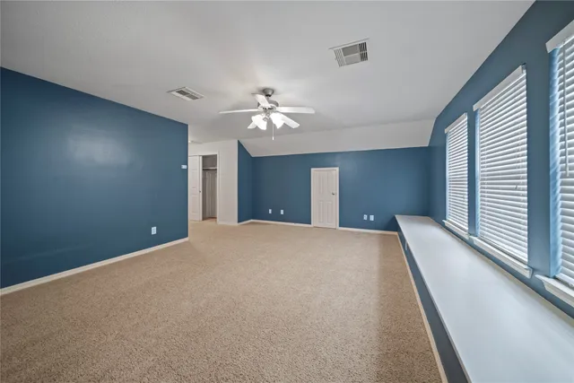 a view of a big room with windows and chandelier fan