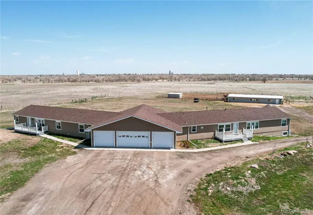 an aerial view of residential houses with outdoor space and ocean view