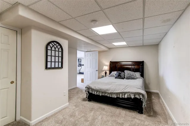 a spacious bedroom with a bed and a flat screen tv
