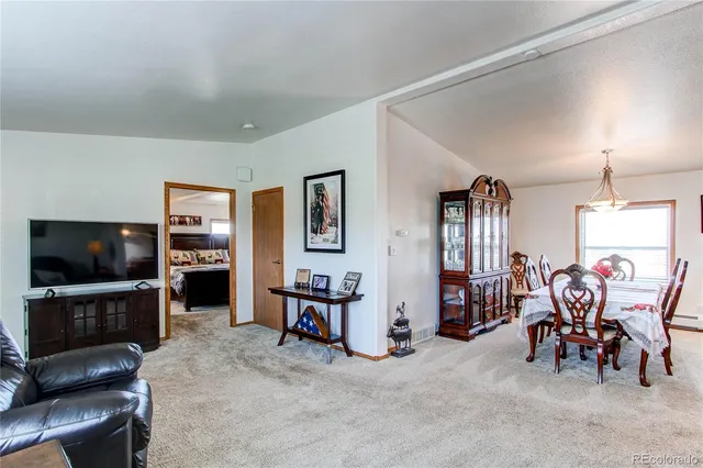 a view of a a dining room with furniture window and wooden floor