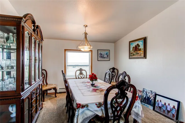 a kitchen with stainless steel appliances granite countertop a stove a sink dishwasher a dining table and chairs with wooden floor