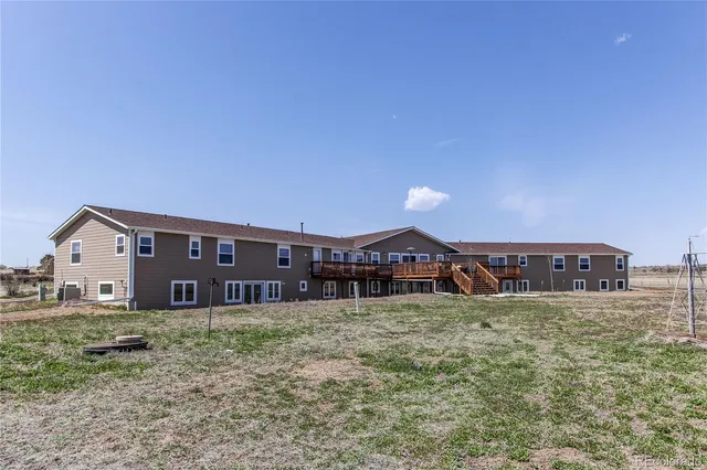 a view of a house with a big yard and large trees