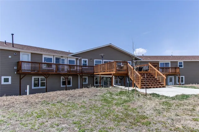 a view of a big house with large windows and a yard